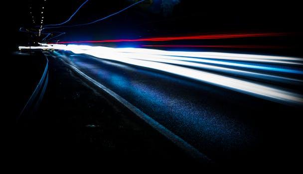 Long exposure shot of vibrant light trails on a highway at night, showing urban motion and speed.